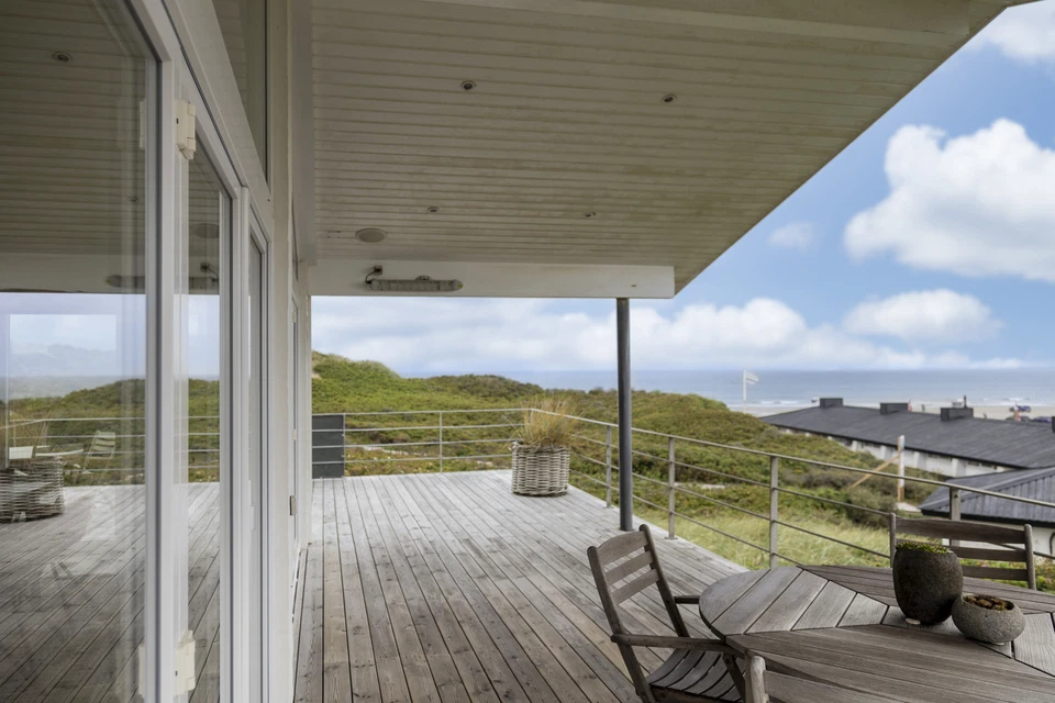 Man standing infront of the ocean with his arms spread out