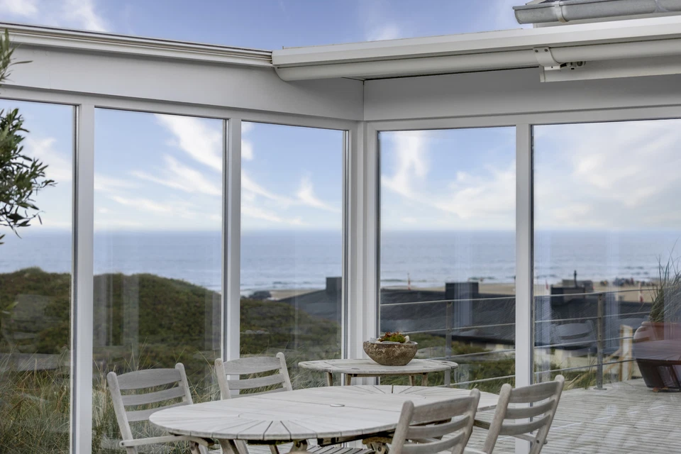 Man standing infront of the ocean with his arms spread out